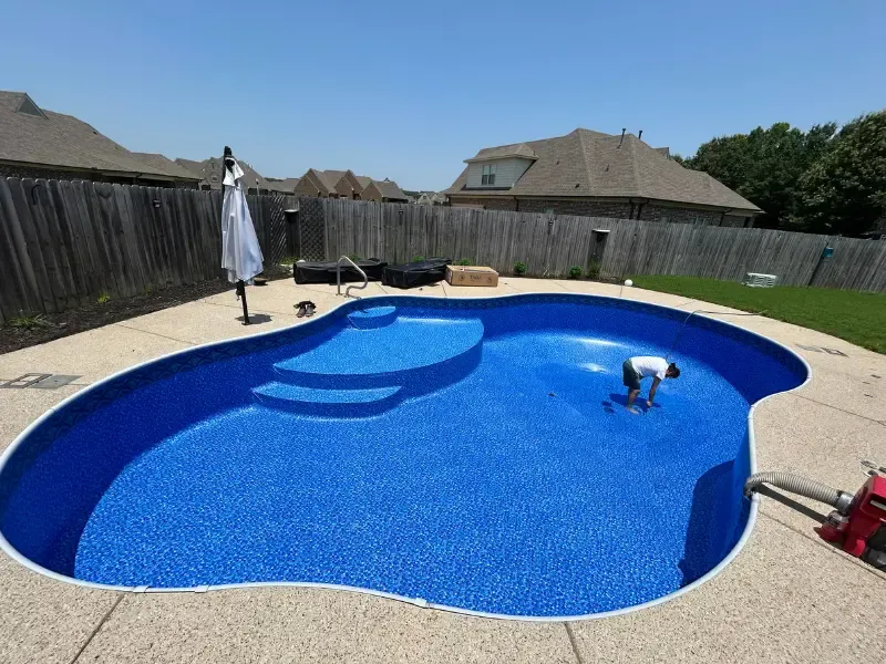Person installing a pool liner in the Memphis heat.