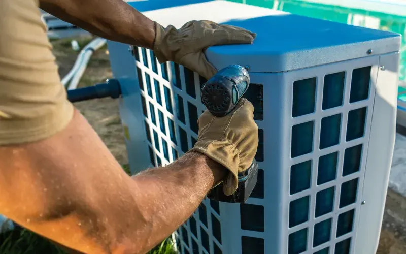 Person installing a pool pump heater.