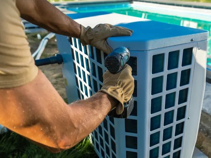 Person installing a pool pump heater.