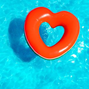 Heart shaped floatie in a swimming pool.